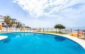 Benalmadena CostaSurf house的一个蓝色的大型游泳池,背景是大海
