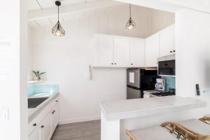 奥欣赛德Pacific Villas的厨房配有白色橱柜和台面