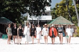 班塔延岛In Dai Aquasports and Beach Resort的一群站在海滩上的妇女