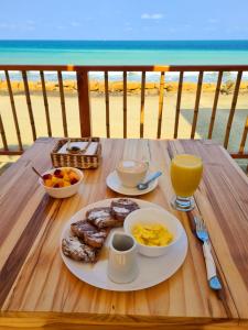 曼塔Intiquilla Hotel的一张带一盘早餐食品的桌子,享有海滩美景