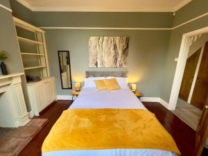 诺里奇Stylish 4 bed house with parking in central Norwich的一间卧室配有一张带黄色毯子的大床