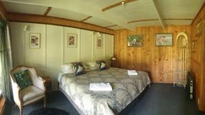 WaimihaBlackfern Lodge的一间卧室配有一张床和一把椅子