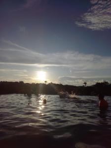 皮雷诺波利斯Resort Quinta Santa Barbara 18 a 24 Agosto的日落时分水面上的一群人