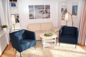 达普Blockhaus mit schoenem Grundstueck的客厅配有两把椅子、一张沙发和一张桌子