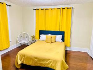 梅肯Southern Comfort Retreat的一间卧室配有黄色的床和黄色窗帘