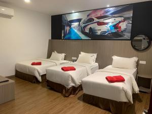 汝来Hype Motorsport Hotel Nilai的酒店客房设有三张床和电视。