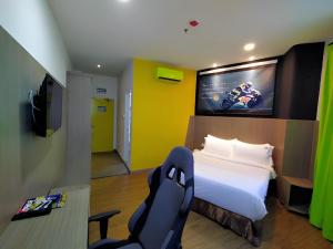 汝来Hype Motorsport Hotel Nilai的一间卧室配有一张床、一台电视和一把椅子