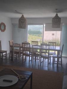 吉亚迪诺镇Sierras de Paz的一间带桌椅和窗户的用餐室