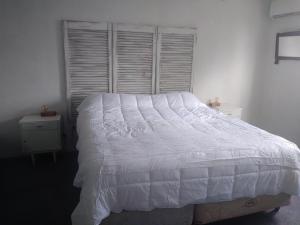 吉亚迪诺镇Sierras de Paz的卧室配有白色的床和窗户。