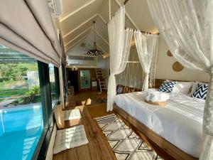 坤西育府Baan Nai Baan Nok Resort的一间卧室设有一张床和一个游泳池