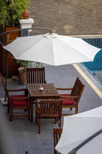 琅勃拉邦沙达酒店的庭院内桌椅和遮阳伞