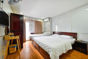 胡志明市Gia Hoa Airport Hotel的一间卧室配有两张床和电视。