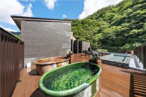 真庭市八景日式旅馆的甲板上的大型绿色浴缸