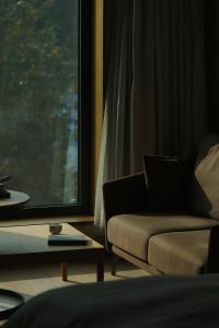 杭州杭州心隅设计师酒店 - 近地铁口,书香江南简约多元设计的带沙发和窗户的客厅