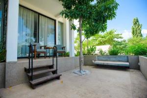 暹粒Tushita Villa, Pool & Gardens的阳台配有桌椅和一棵树。