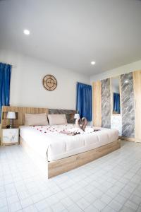 芭东海滩Grand View Premium的一张白色的大床,房间配有蓝色窗帘