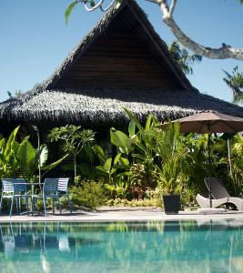 卢纳将军城Kaimana Resort Siargao的一个带椅子和遮阳伞的度假村游泳池