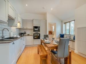 LangsettThe Cottage的厨房配有白色橱柜和木桌
