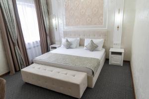 奇姆肯特Dora Hotel的一间卧室配有一张大床和一张沙发