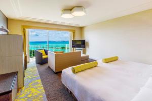 宜野湾市拉格纳花园酒店 的酒店客房设有一张床,享有海景。