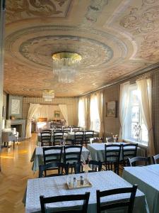 SäterSäters Stadshotell的一间带桌椅和天花板的用餐室
