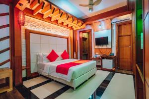FuvahmulahMillennium Island Residence的一间卧室配有红色枕头的床