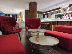 日内瓦勒格雷尼尔酒店的一间设有红色椅子和桌子的等候室