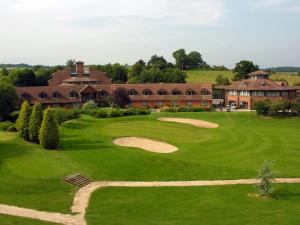 雷迪奇经典英国修道院高尔夫酒店&SPA的享有高尔夫球场空中景色,设有一座大楼