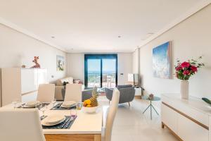 卡萨雷斯2207-Modern apt with terrace and amazing seaview的厨房以及带桌椅的起居室。