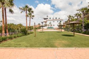 卡萨雷斯2207-Modern apt with terrace and amazing seaview的棕榈树和遮阳伞草坪的度假村