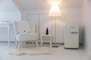 米德尔堡B&B De Kloostertuin的白色的客房设有椅子和冰箱