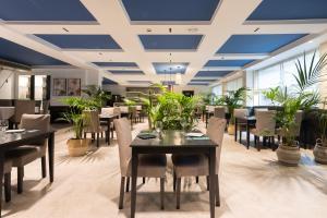 圣克鲁斯-德特内里费科隆兰布拉酒店的用餐室配有桌椅和植物
