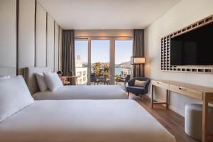 里斯本Hyatt Regency Lisbon的酒店客房设有两张床和一台平面电视。