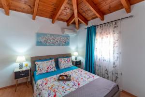 科林比亚Posidonia Luxury Villas Kolympia的一间卧室设有一张床和木制天花板