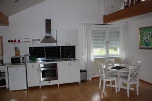 布兰肯海姆Ferienwohnung Nett的厨房配有白色橱柜和桌椅