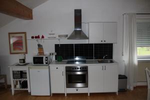 布兰肯海姆Ferienwohnung Nett的厨房配有白色橱柜和炉灶烤箱。