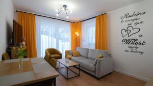 维斯瓦Apartamenty Sun & Snow Spokojna的客厅配有沙发和桌子