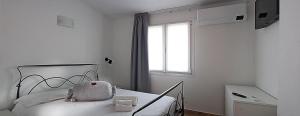 RudaAgriturismo Pelos的白色的卧室设有床和窗户
