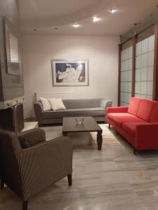 特里卡拉Elegante apartamento centrale的客厅配有红色的沙发和桌子
