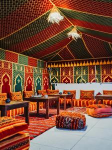 塔姆拉赫特乌兹达尔cactus surf house的配有桌椅和彩色墙壁的客房