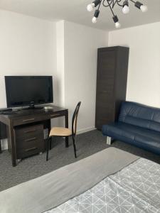 卡利什Apartament Szaława的客厅配有沙发和书桌及电视