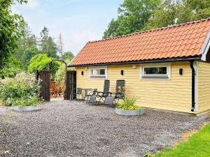 FärlövHoliday home FÄRLÖV的黄色的小房子,有橙色的屋顶