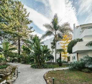 马贝拉Puente Romano Beach Suites - private apartaments的棕榈树庭院和建筑