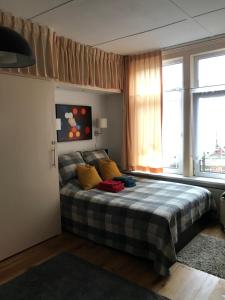 阿姆斯特丹Six的一间卧室配有一张带黄色枕头的床和一扇窗户