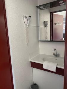 蒙德马桑Fasthotel Mont de Marsan的一间带水槽的浴室和墙上的一部电话