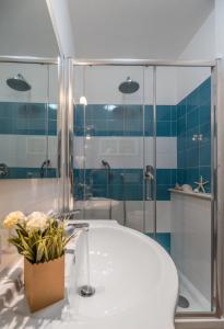 博萨Bosa Queen House的带浴缸和玻璃淋浴间的浴室。