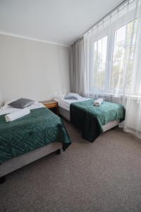 克拉科夫费利克斯酒店的一间卧室设有两张床和窗户。
