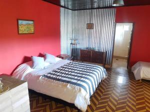 Dos PozosLa Antonieta Estancia de Mar的一间拥有红色墙壁的卧室和一张位于客房内的床