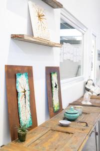 阿罗纳Little Square Arona的木桌,墙上挂着两件艺术品
