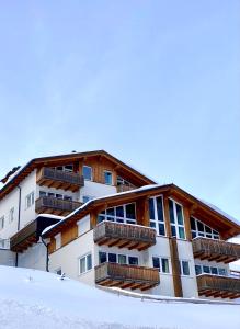 上陶恩Obertauern Fewo Top 12 by Kamper的一座在雪中带阳台的建筑